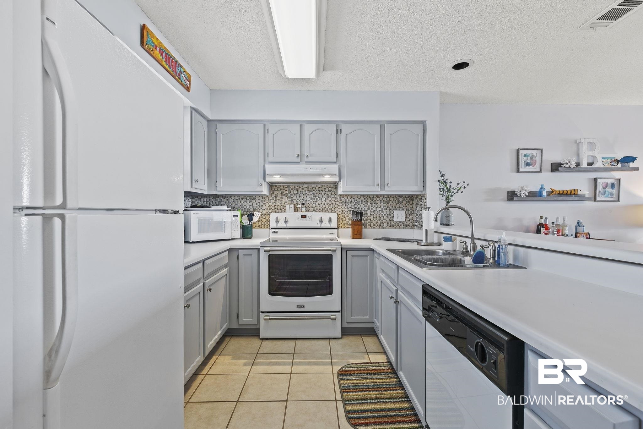 25861 Canal Road, Unit 78 Orange Beach, AL 36561 - Photo 7 of 45 Kitchen featuring gray cabinets, white appliances, range hood, and a sink