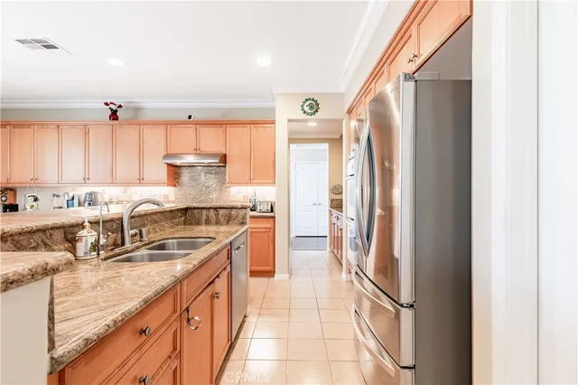 a kitchen with stainless steel appliances granite countertop a sink and a refrigerator
