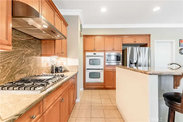 a kitchen with stainless steel appliances granite countertop a stove a sink and a refrigerator