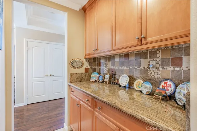 a kitchen with granite countertop a sink a stove and cabinets