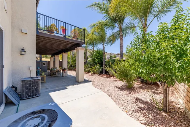 a view of a patio with table and chairs potted plants and floor to ceiling window