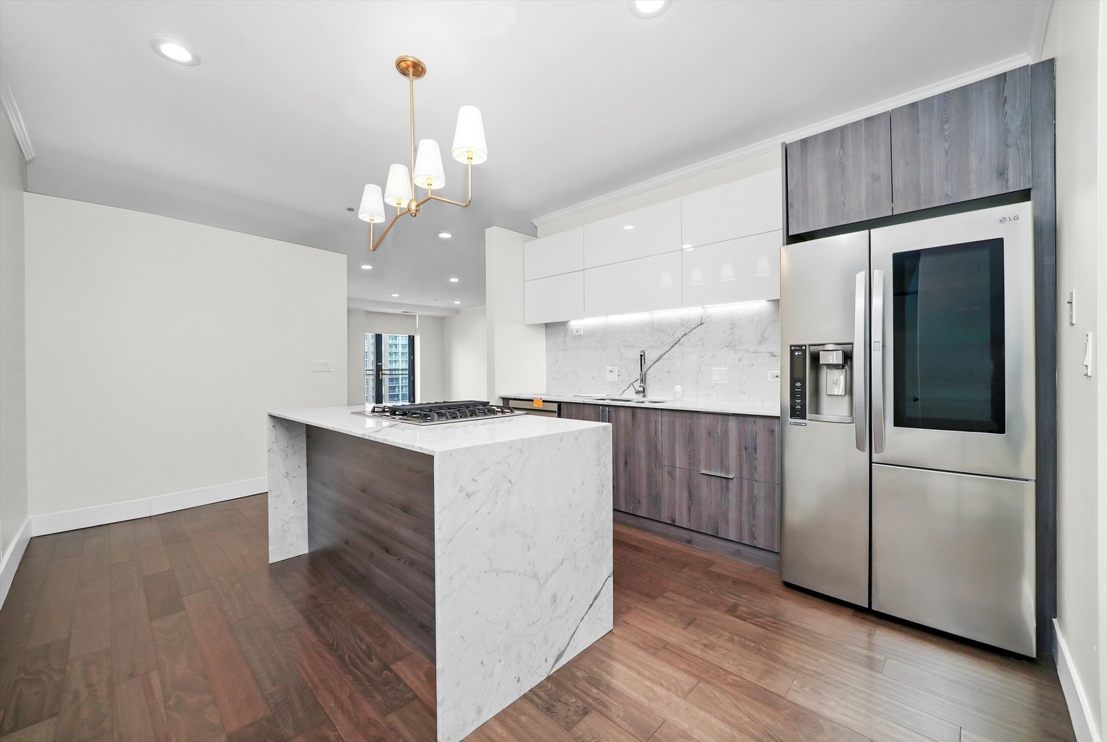 910 South Michigan Avenue, Unit 1612 Chicago, IL 60605 - Photo 6 of 17 a kitchen with kitchen island white cabinets and stainless steel appliances