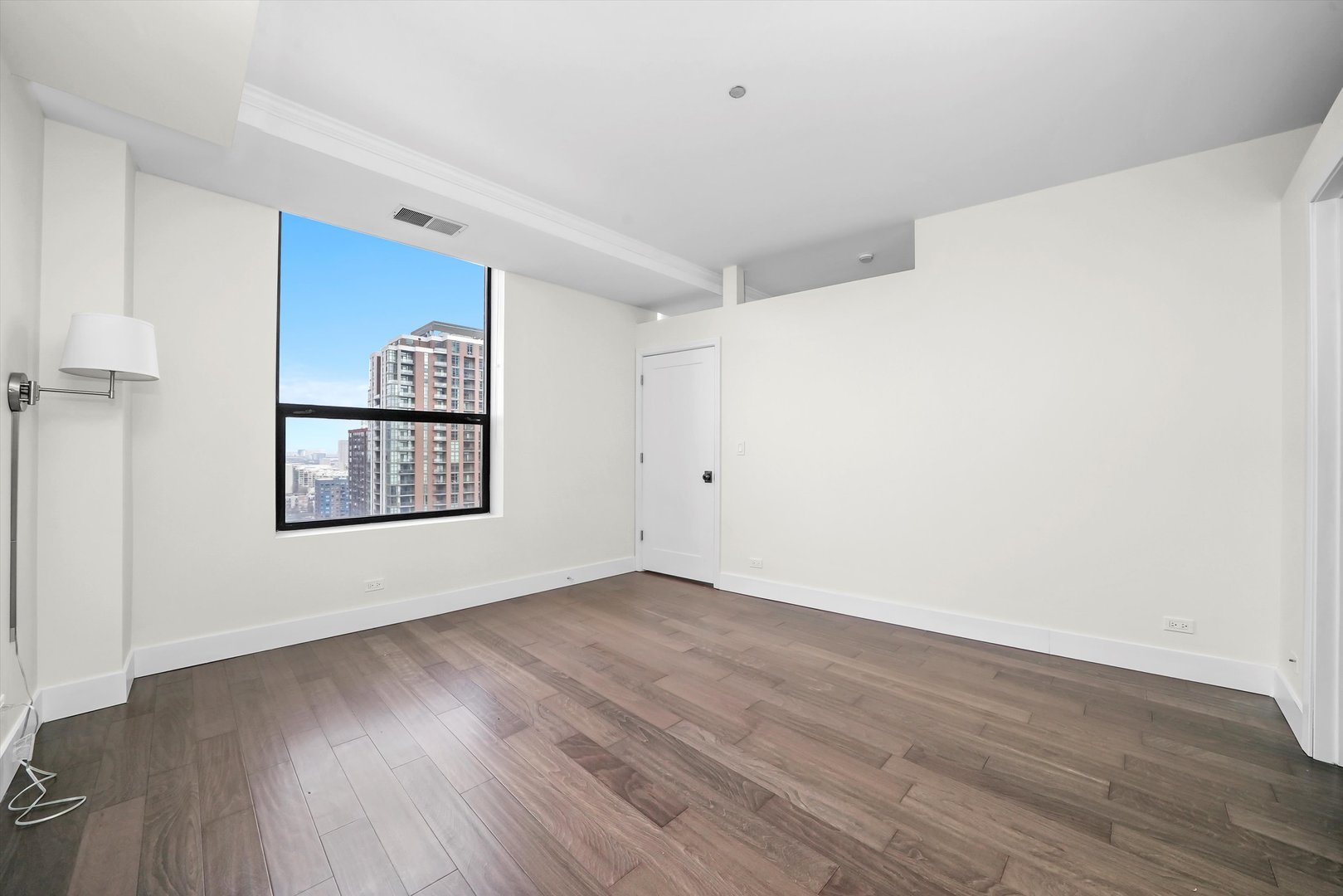 910 South Michigan Avenue, Unit 1612 Chicago, IL 60605 - Photo 9 of 17 a view of an empty room with wooden floor and a window