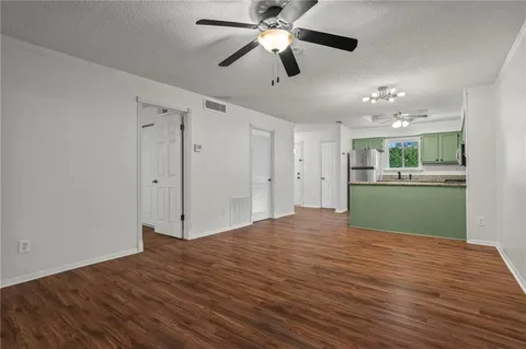 a view of an empty room with window and wooden floor