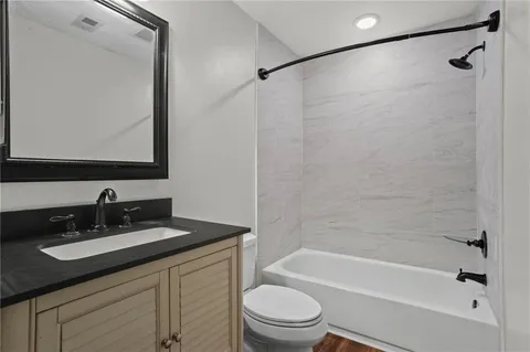 a bathroom with a bathtub shower sink vanity and toilet