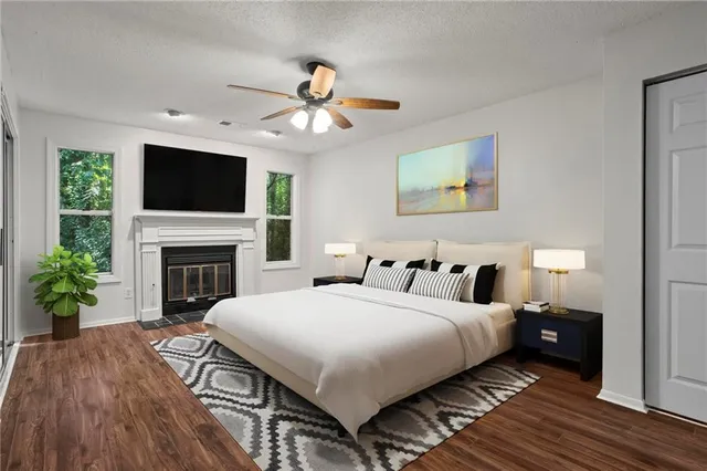 a large bedroom with a large bed a flat tv screen and a fireplace
