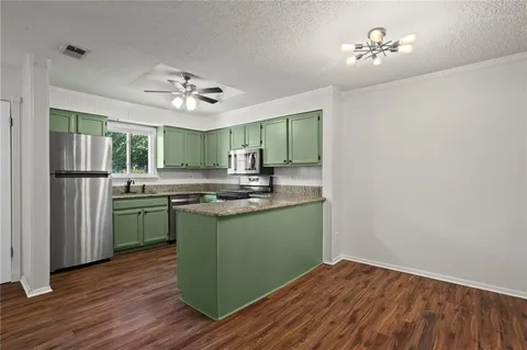 a kitchen with kitchen island stainless steel appliances a chandelier and wooden floor