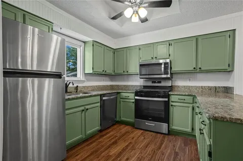 a kitchen with stainless steel appliances granite countertop a refrigerator sink and microwave