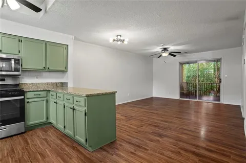 a kitchen with cabinets and wooden floor