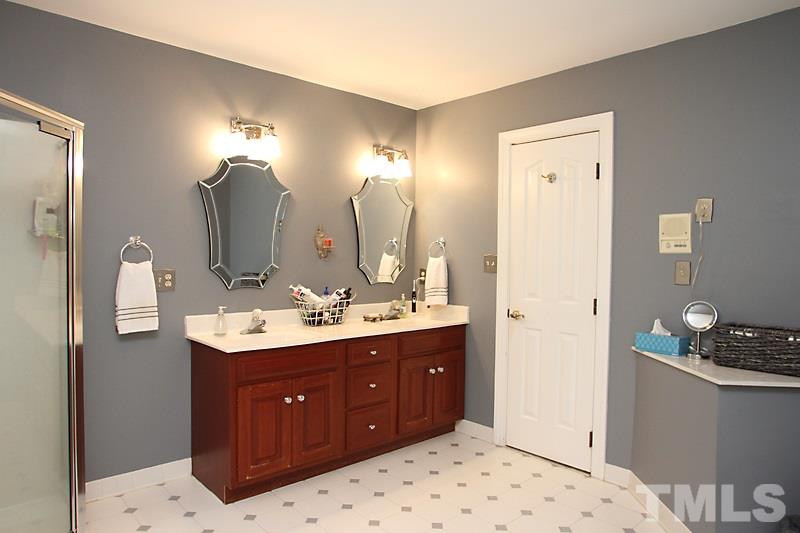 12301 Staunton Court Raleigh, NC 27613 - Photo 14 of 25 a spacious bathroom with a sink double vanity and a mirror