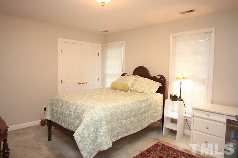 12301 Staunton Court Raleigh, NC 27613 - Photo 16 of 25 a bedroom with a bed and cabinets