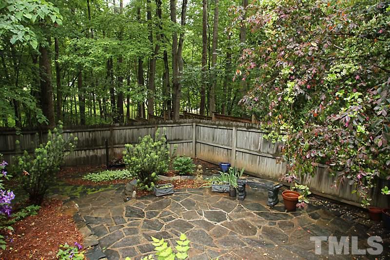 12301 Staunton Court Raleigh, NC 27613 - Photo 21 of 25 a backyard of a house with lots of green space and fountain view