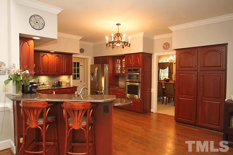 12301 Staunton Court Raleigh, NC 27613 - Photo 6 of 25 a kitchen with stainless steel appliances wooden floors cabinets and wooden floor
