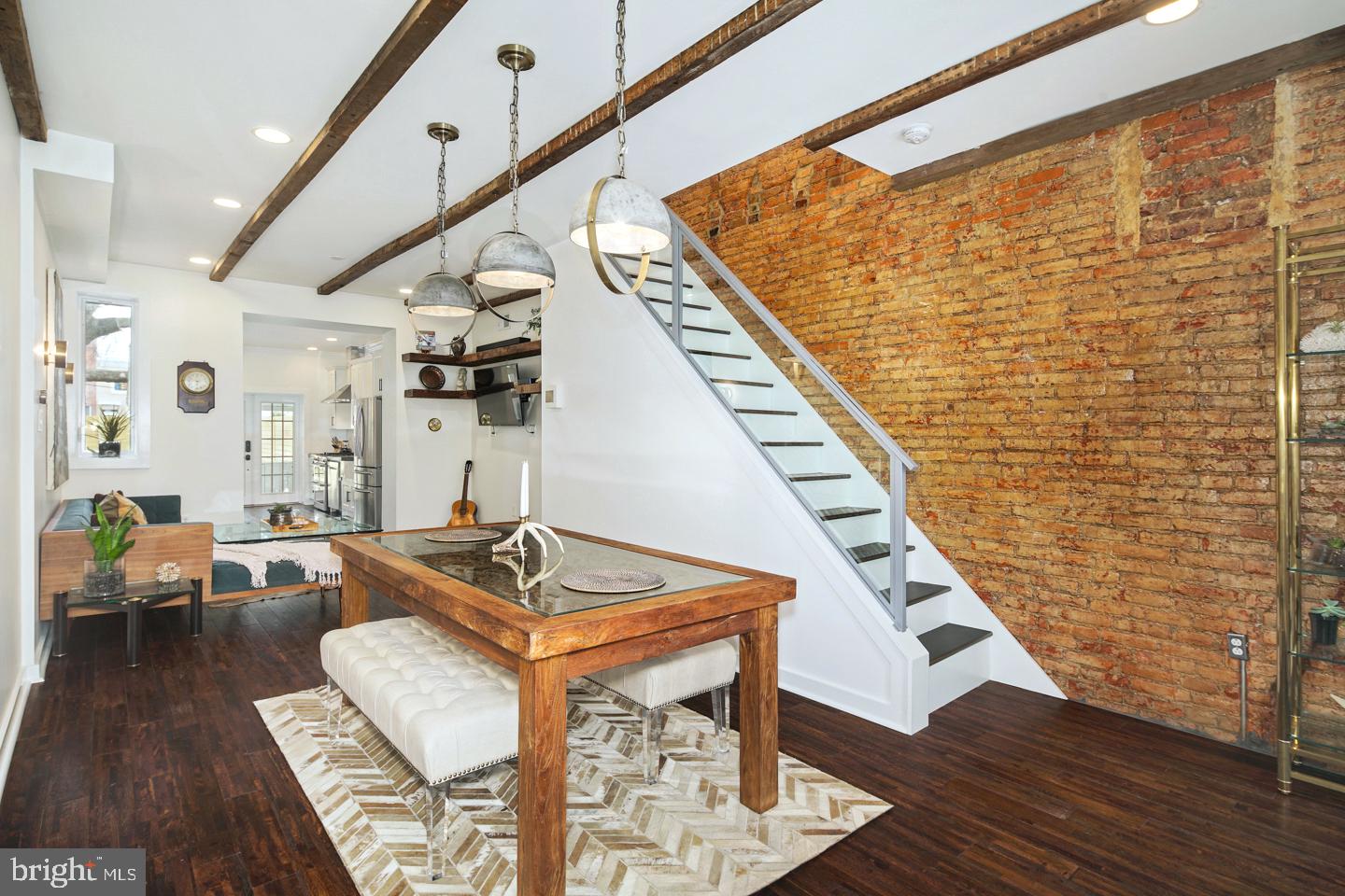 a living room with couches bookshelf and a stove with wooden floor