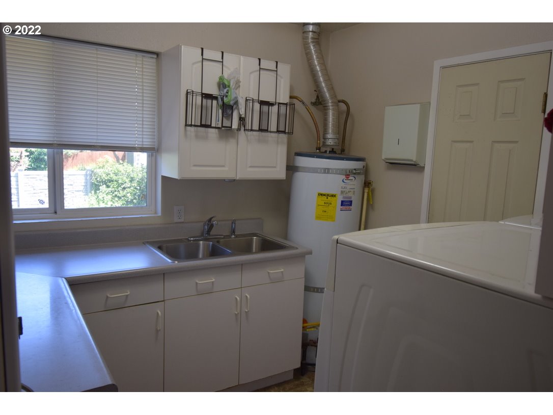 8717 Northeast Webster Street Portland, OR 97220 - Photo 15 of 30 a kitchen with a sink a refrigerator and window