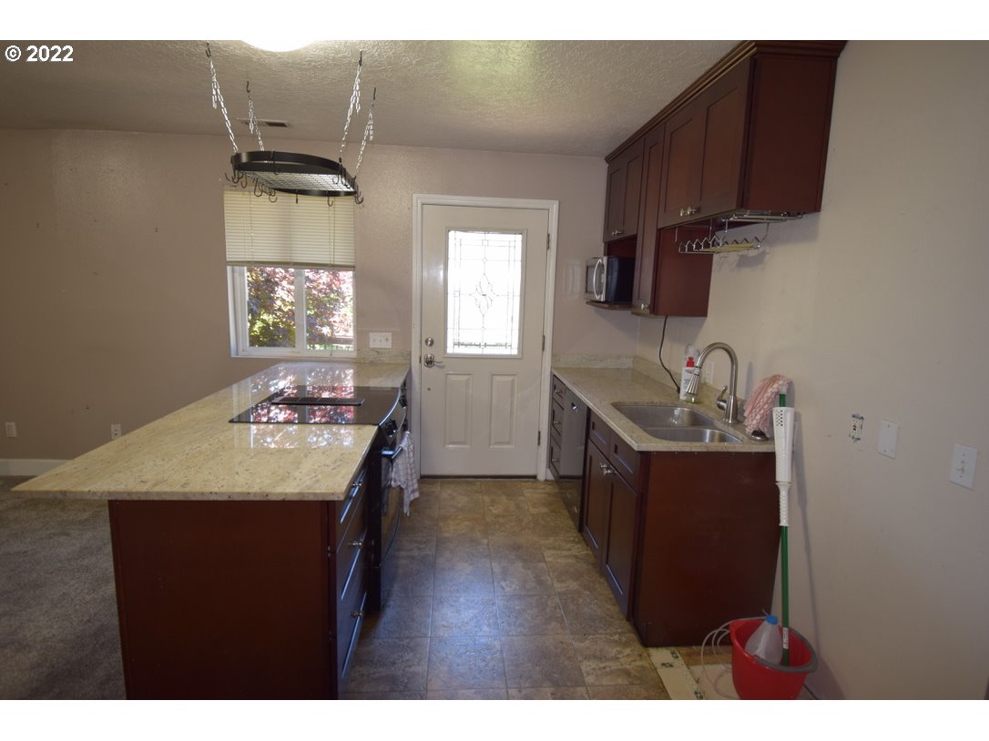 8717 Northeast Webster Street Portland, OR 97220 - Photo 21 of 30 a kitchen with a sink stove and cabinets