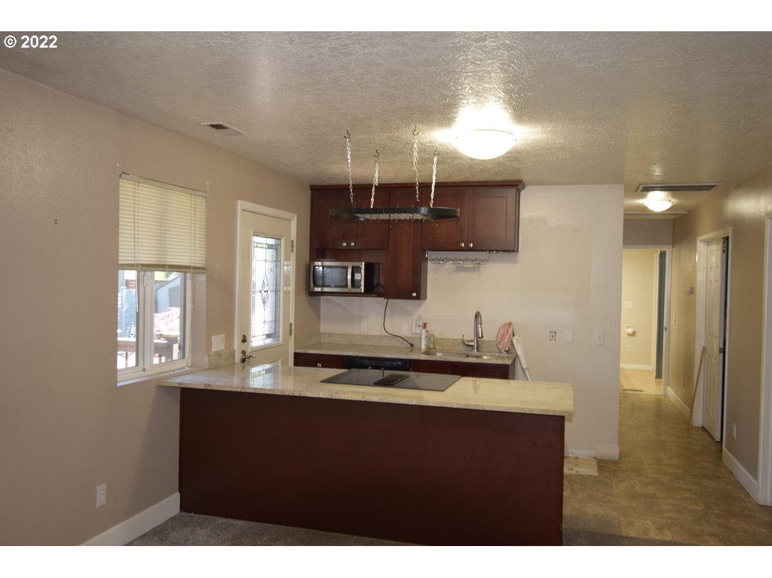8717 Northeast Webster Street Portland, OR 97220 - Photo 22 of 30 a kitchen with kitchen island a sink appliances and a counter top space