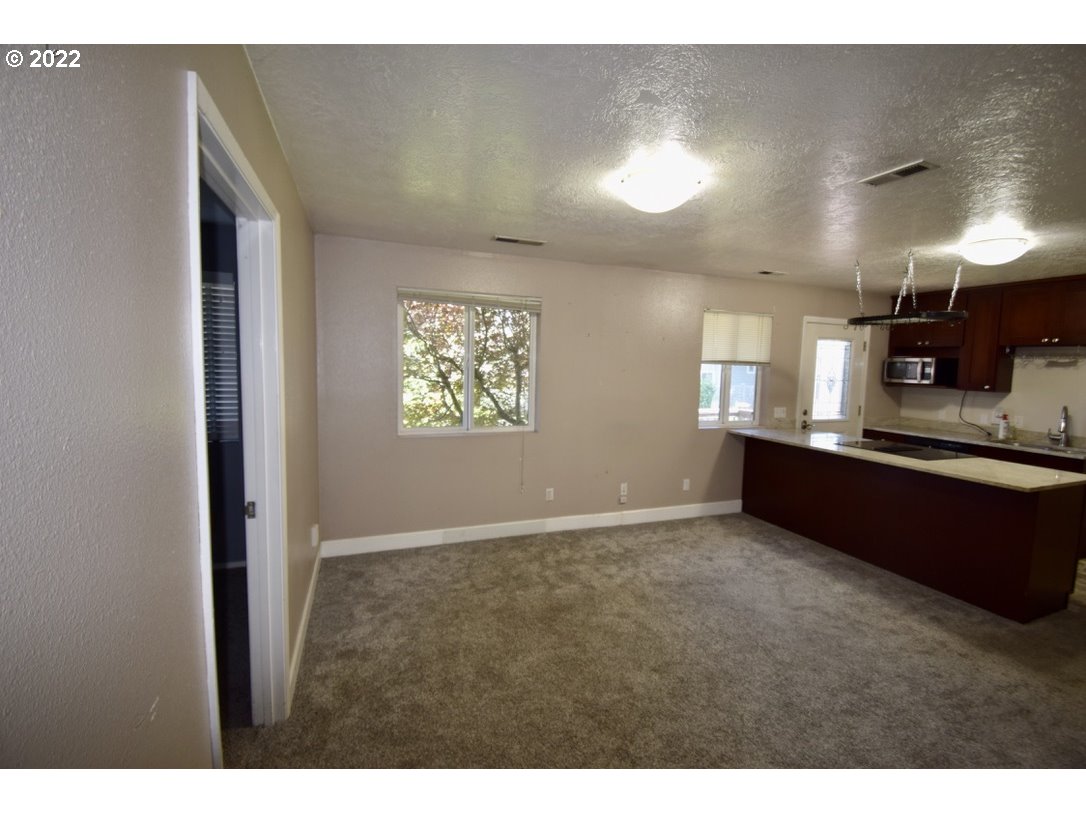 8717 Northeast Webster Street Portland, OR 97220 - Photo 23 of 30 a view of an empty room and a kitchen