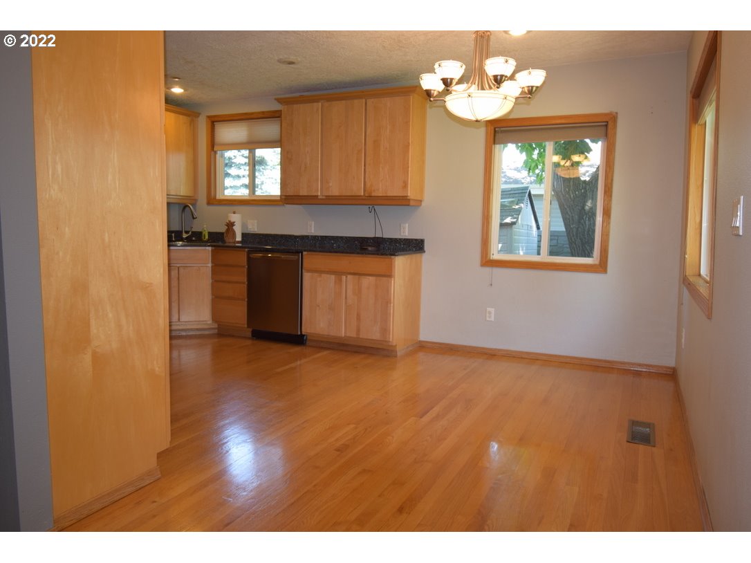 8717 Northeast Webster Street Portland, OR 97220 - Photo 6 of 30 a view of an empty room with window and wooden floor