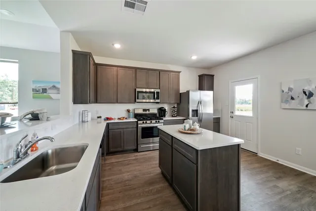 a kitchen with a sink stove a sink dishwasher and a refrigerator