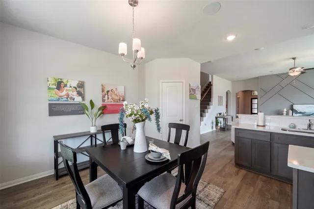 a view of a dining room with furniture a chandelier and wooden floor