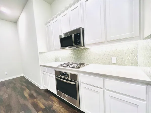 a kitchen with white cabinets and stainless steel appliances