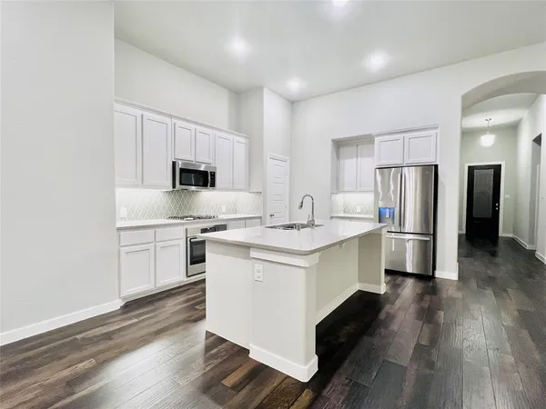a kitchen with stainless steel appliances a sink stove and refrigerator