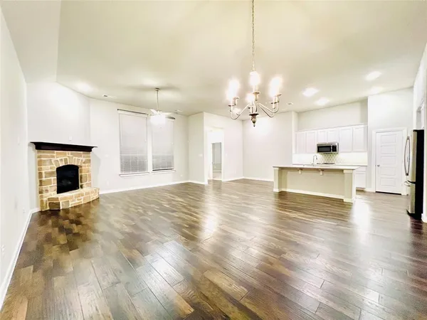 a view of empty room with wooden floor and fireplace