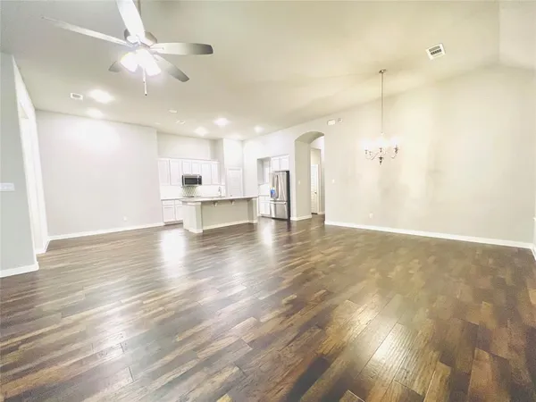 a view of an empty room and kitchen view