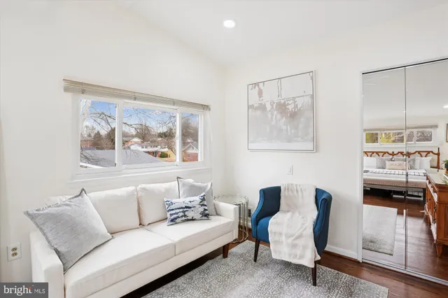 a living room with furniture and a painting on the wall