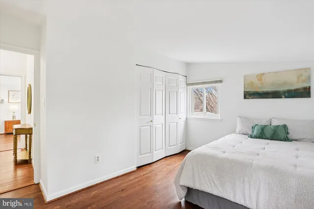 a bedroom with a bed and a painting on the wall