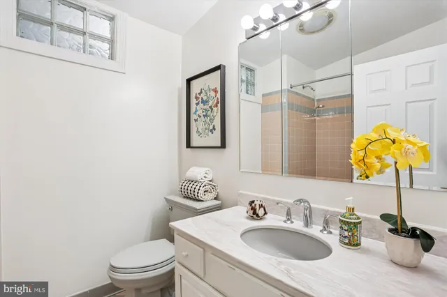 a bathroom with a sink vanity mirror and toilet