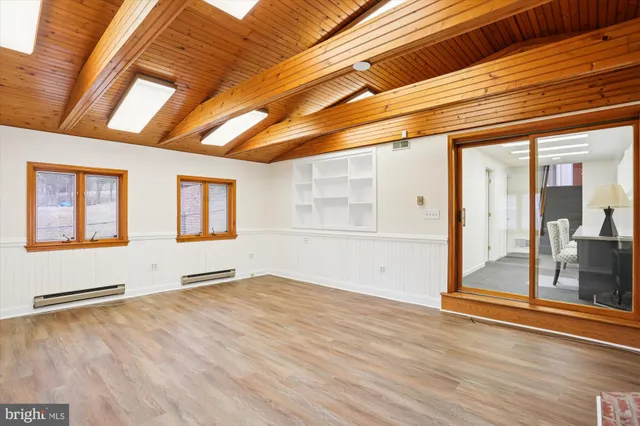 a room with a chair and a view of kitchen