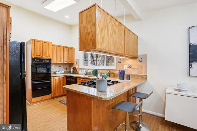 a kitchen with stainless steel appliances kitchen island granite countertop a refrigerator and a stove top oven