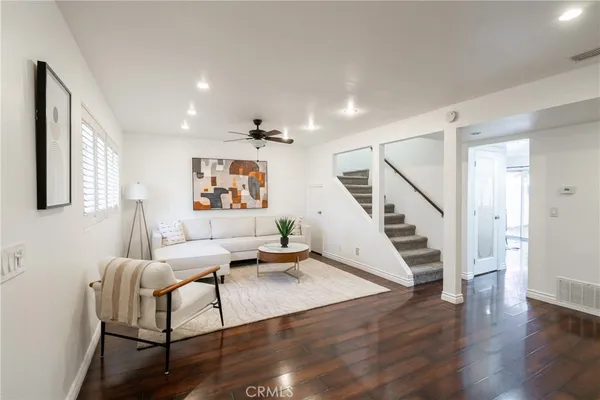 a living room with furniture and wooden floor