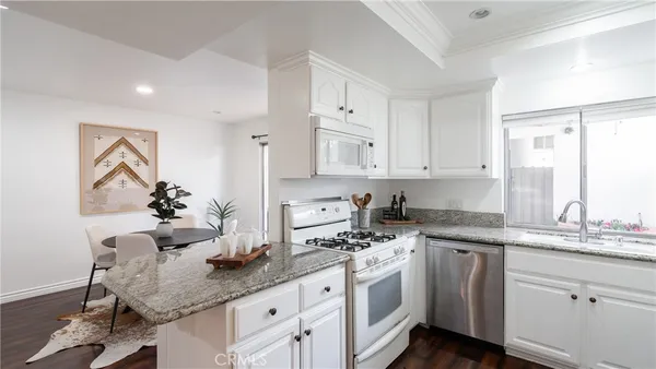 a kitchen with stainless steel appliances granite countertop a sink stove and cabinets