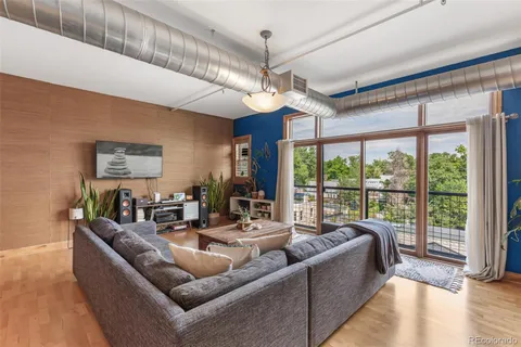 a living room with furniture ceiling fan and a large window