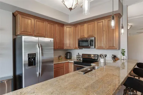 a kitchen with stainless steel appliances granite countertop a refrigerator a stove top oven a sink and dishwasher