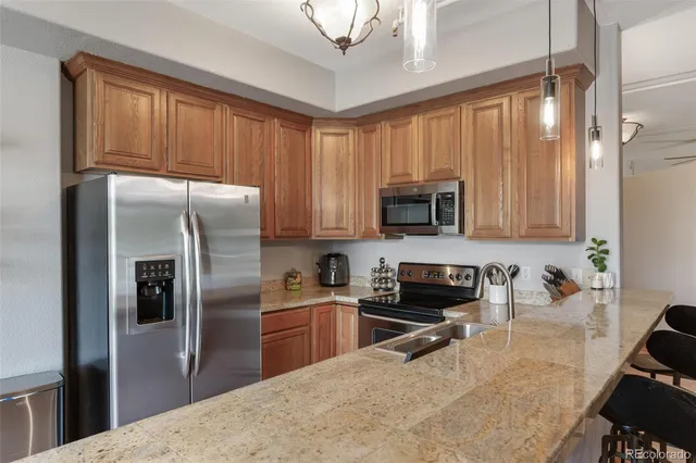 a kitchen with stainless steel appliances granite countertop a refrigerator a stove top oven a sink and dishwasher