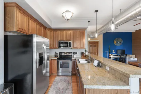 a kitchen with stainless steel appliances a table chairs refrigerator and microwave