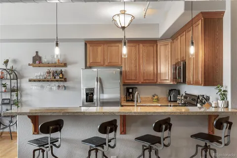 a kitchen with stainless steel appliances granite countertop a sink and a refrigerator