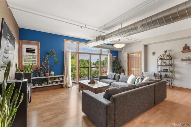 a living room with furniture large window and flat screen tv