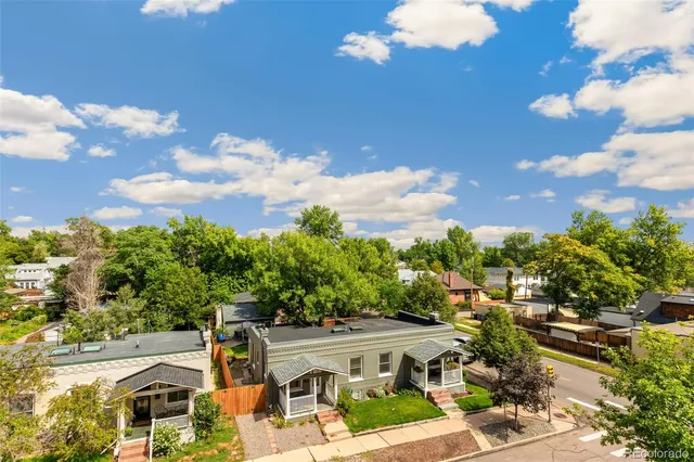 a living room with furniture kitchen view and a wooden floor