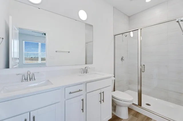 a bathroom with a sink a toilet and shower