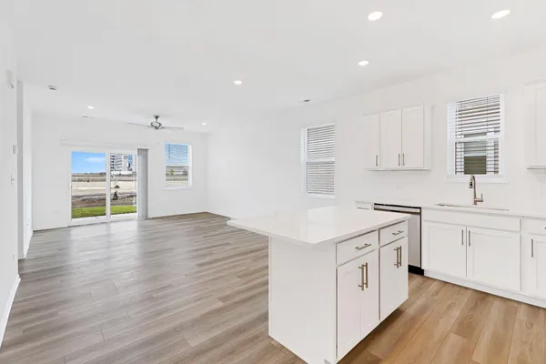 a kitchen with stainless steel appliances a sink cabinets and wooden floor