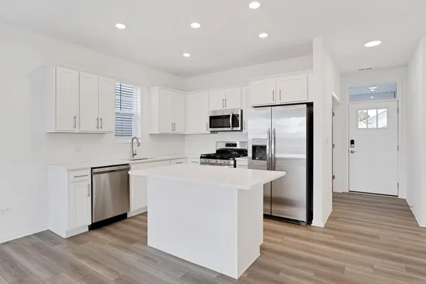 a kitchen with white cabinets and stainless steel appliances
