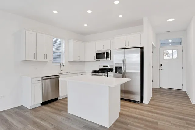 a kitchen with white cabinets and stainless steel appliances