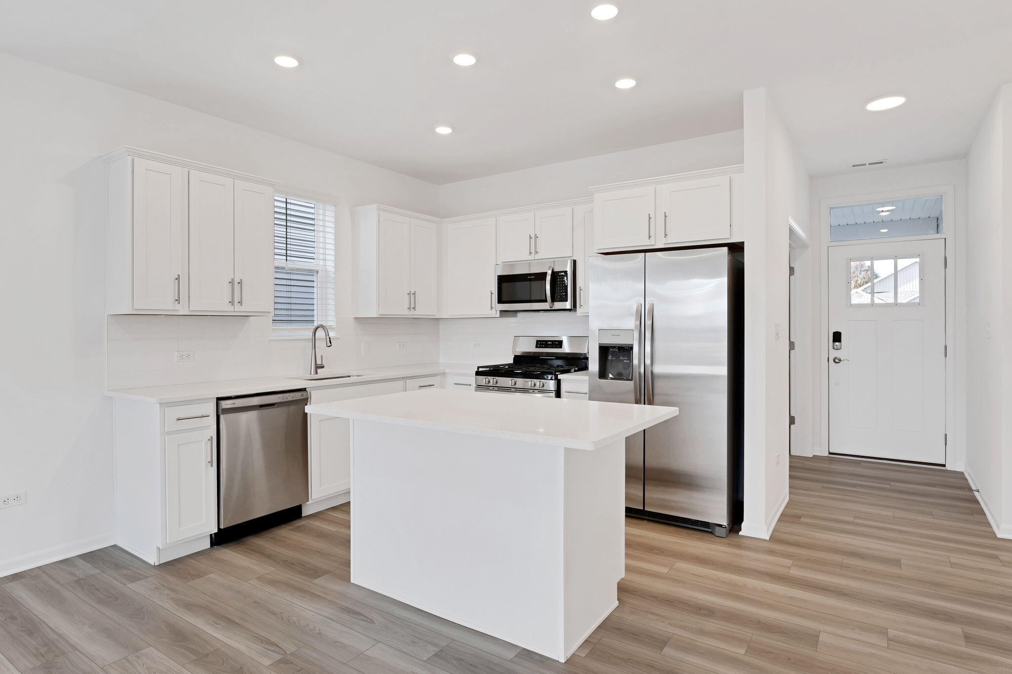 511 East 127th Place Crown Point, IN 46307 - Photo 6 of 22 a kitchen with white cabinets and stainless steel appliances