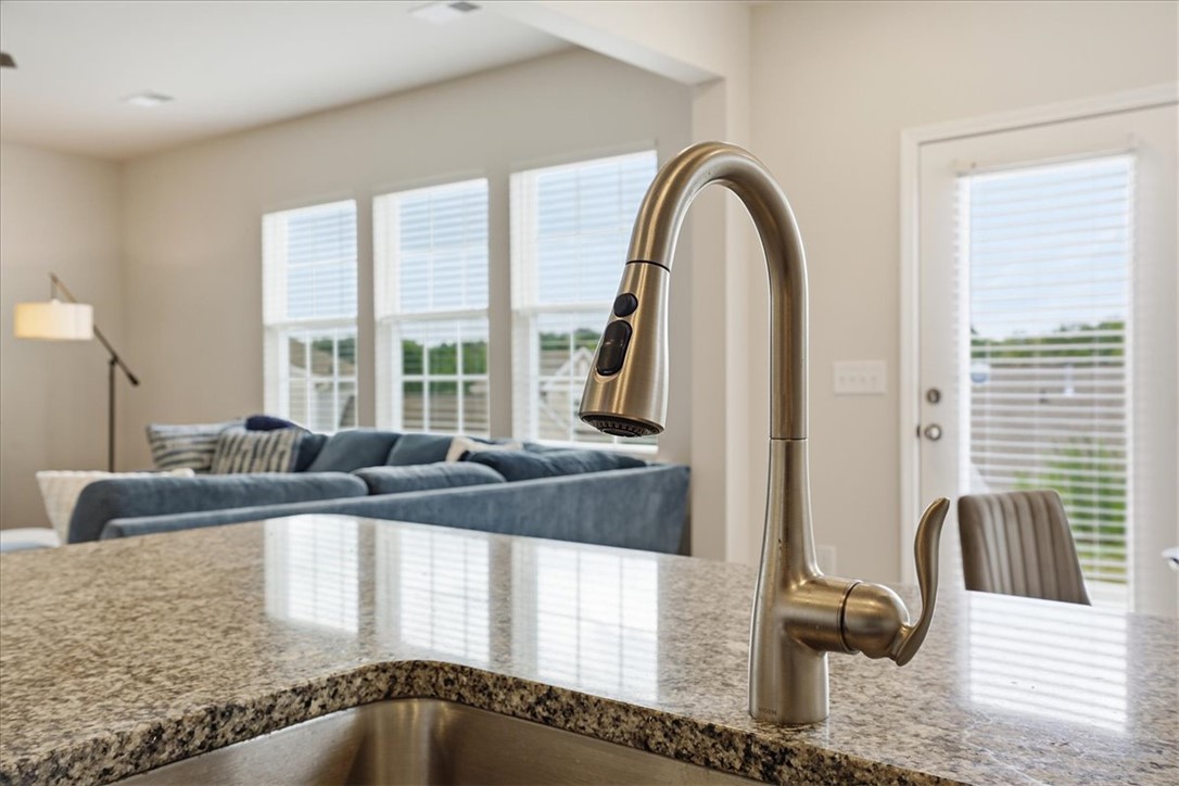 365 Sliding Rock Drive Pendleton, SC 29670 - Photo 13 of 46 Granite counters and a pull-down faucet grace this kitchen island, opening to a sun-filled living area.
