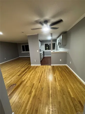 a view of empty room with wooden floor